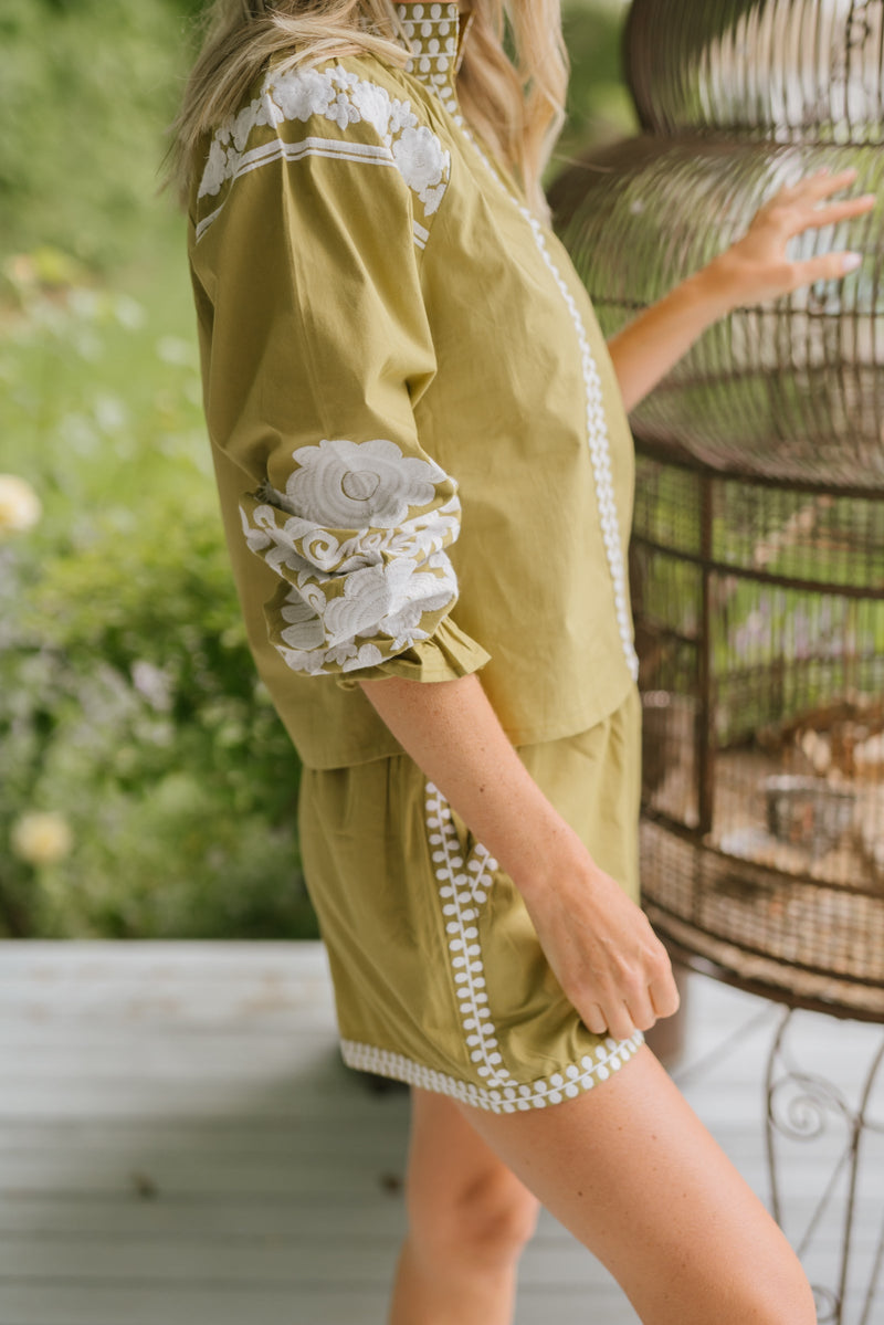 Close up of white embroidery by Julia Amory green top 